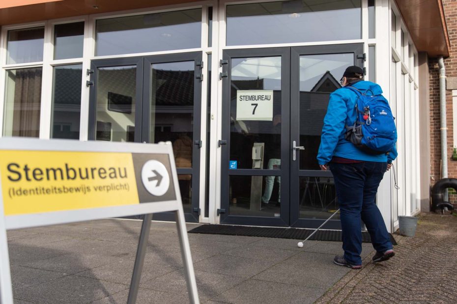 Iemand loopt naar de ingang van een stemlocatie