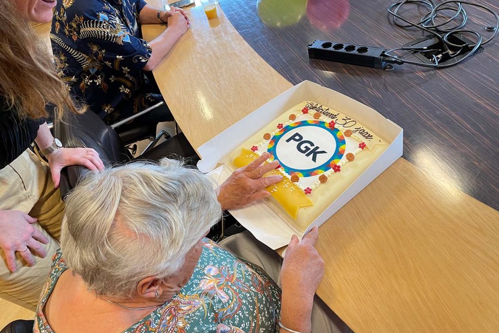 Elvira bevoelt de braille letters op de taart.