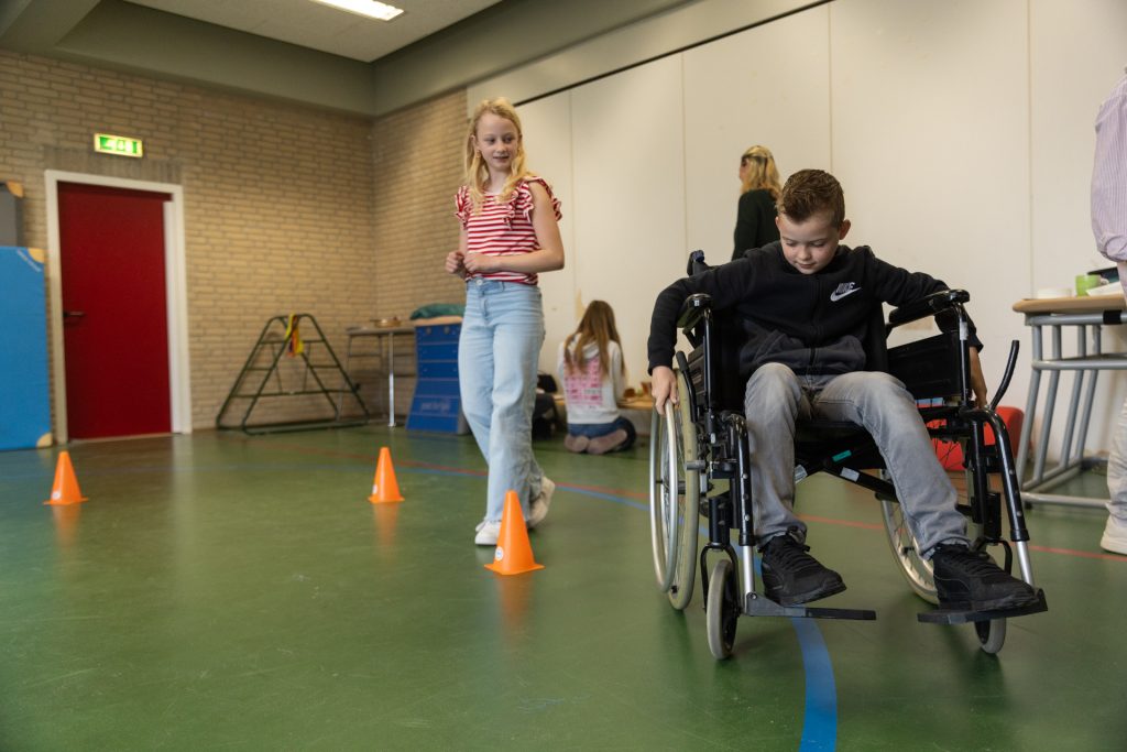 Kinderen ervaren hoe het is om in een rolstoel rond te rijden