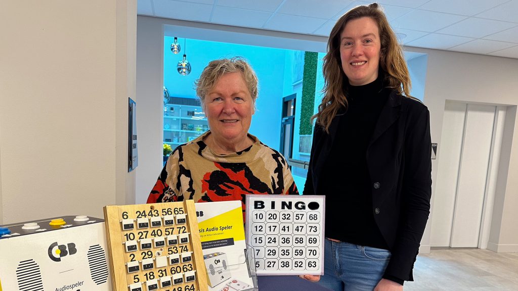 Vrijwilliger Marijke presenteert bingo kaarten bij CBB