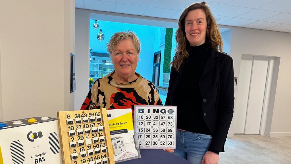 Vrijwilliger Marijke presenteert bingo kaarten bij CBB